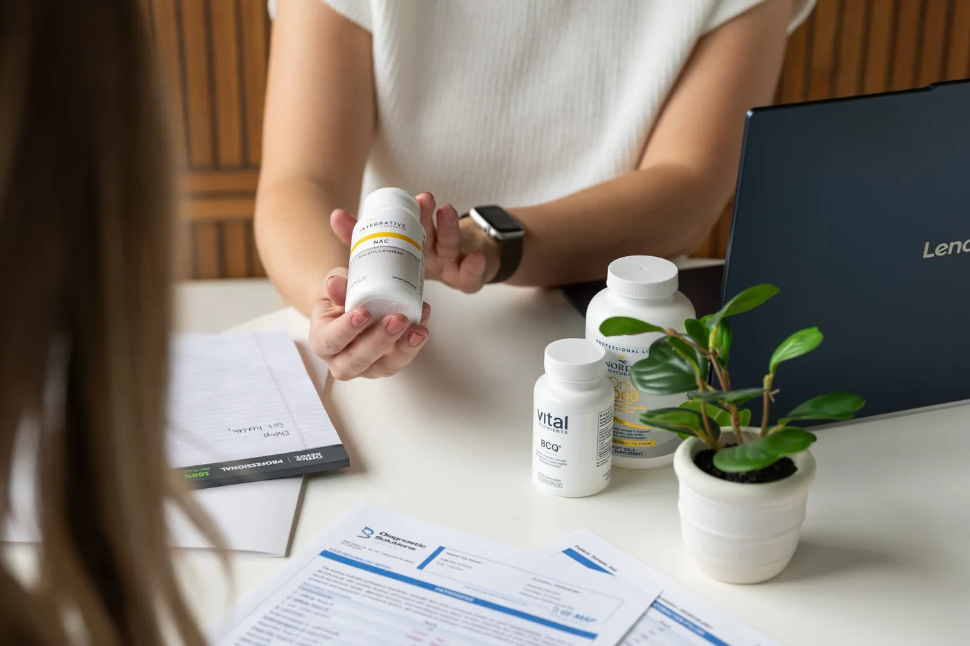A lab requisition and printed test results laid out on a table during a patient visit